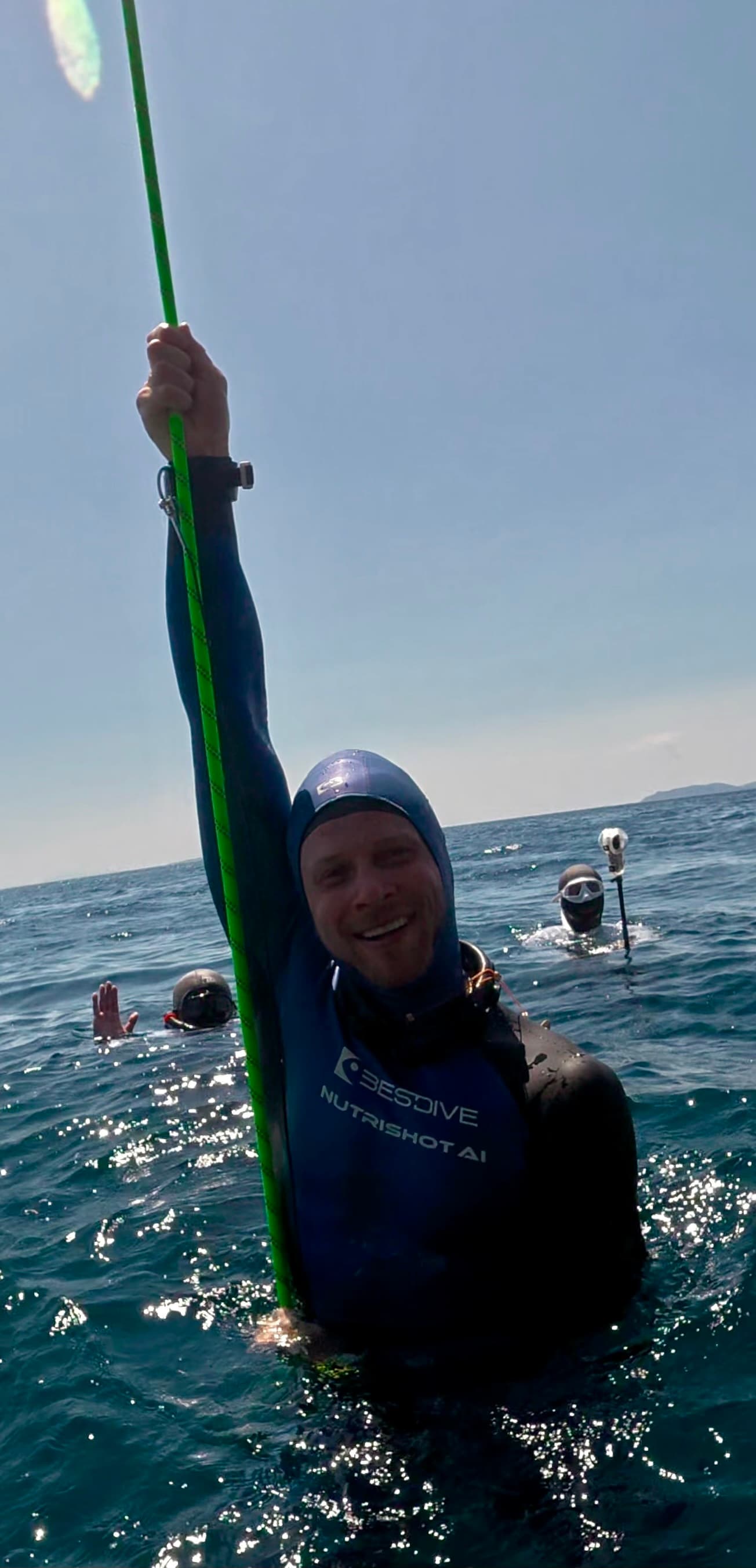Quest, founder of NutriShot AI, surfacing from a freediving training dive in his NutriShot AI wetsuit